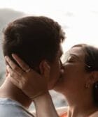 A couple kissing in front of a city view